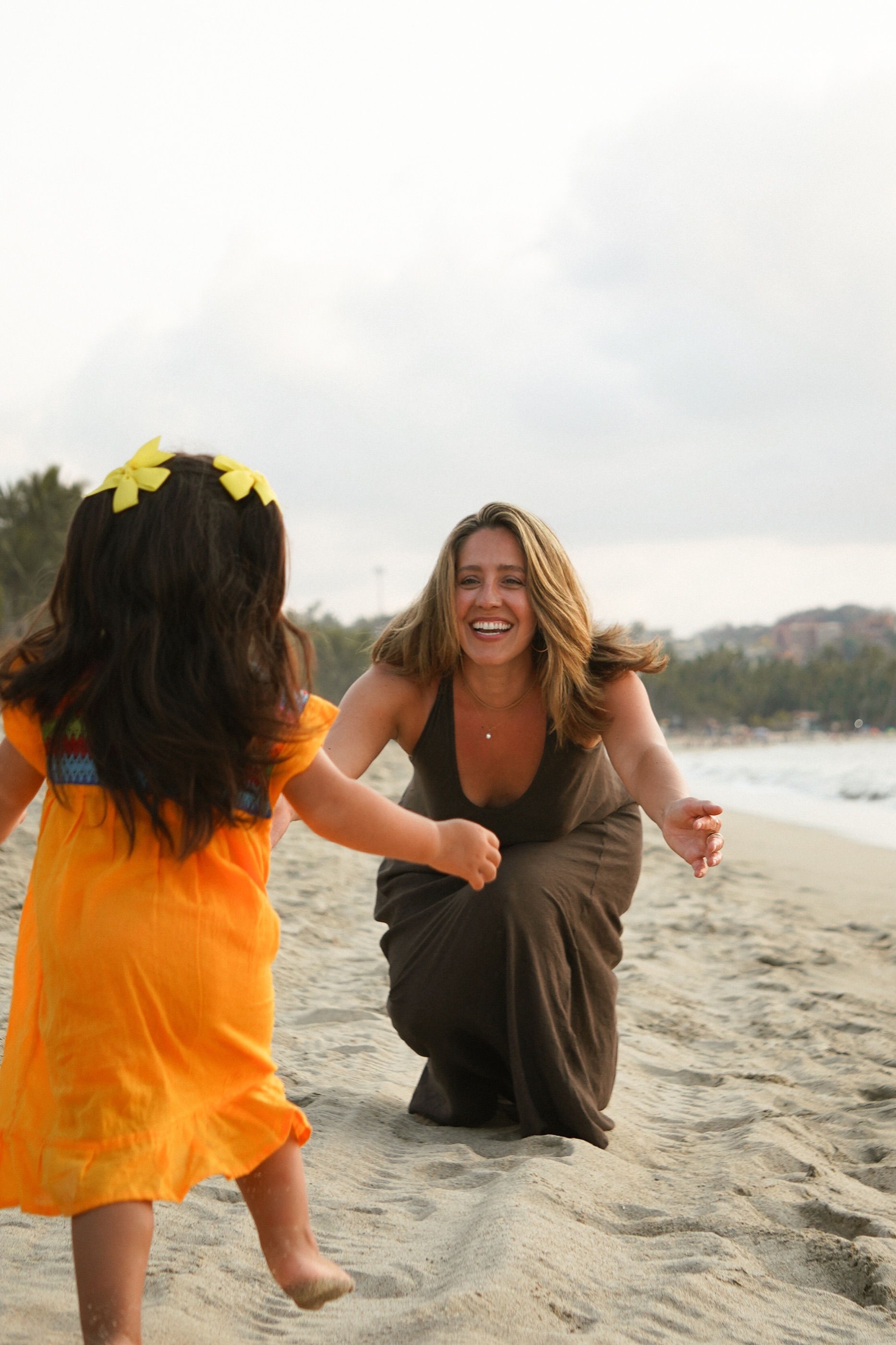 Niki welcoming her daughter on a beach
